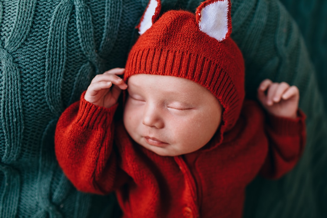 baby in red knit cap and red sweater