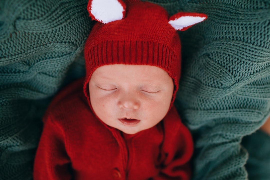 baby in red knit cap and red jacket