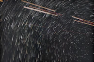 A time-lapse photo showing star trails circling the night sky.
