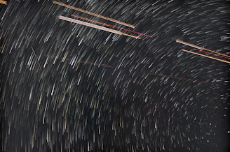 A time-lapse photo showing star trails circling the night sky.