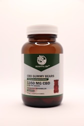 A brown glass bottle with a white cap contains CBD gummy bears. The label indicates THC-free broad-spectrum extract with 1350 mg of CBD. The flavor is delightful watermelon, and there are 30 gummies per bottle.