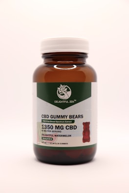 A brown glass bottle with a white cap contains CBD gummy bears. The label indicates THC-free broad-spectrum extract with 1350 mg of CBD. The flavor is delightful watermelon, and there are 30 gummies per bottle.