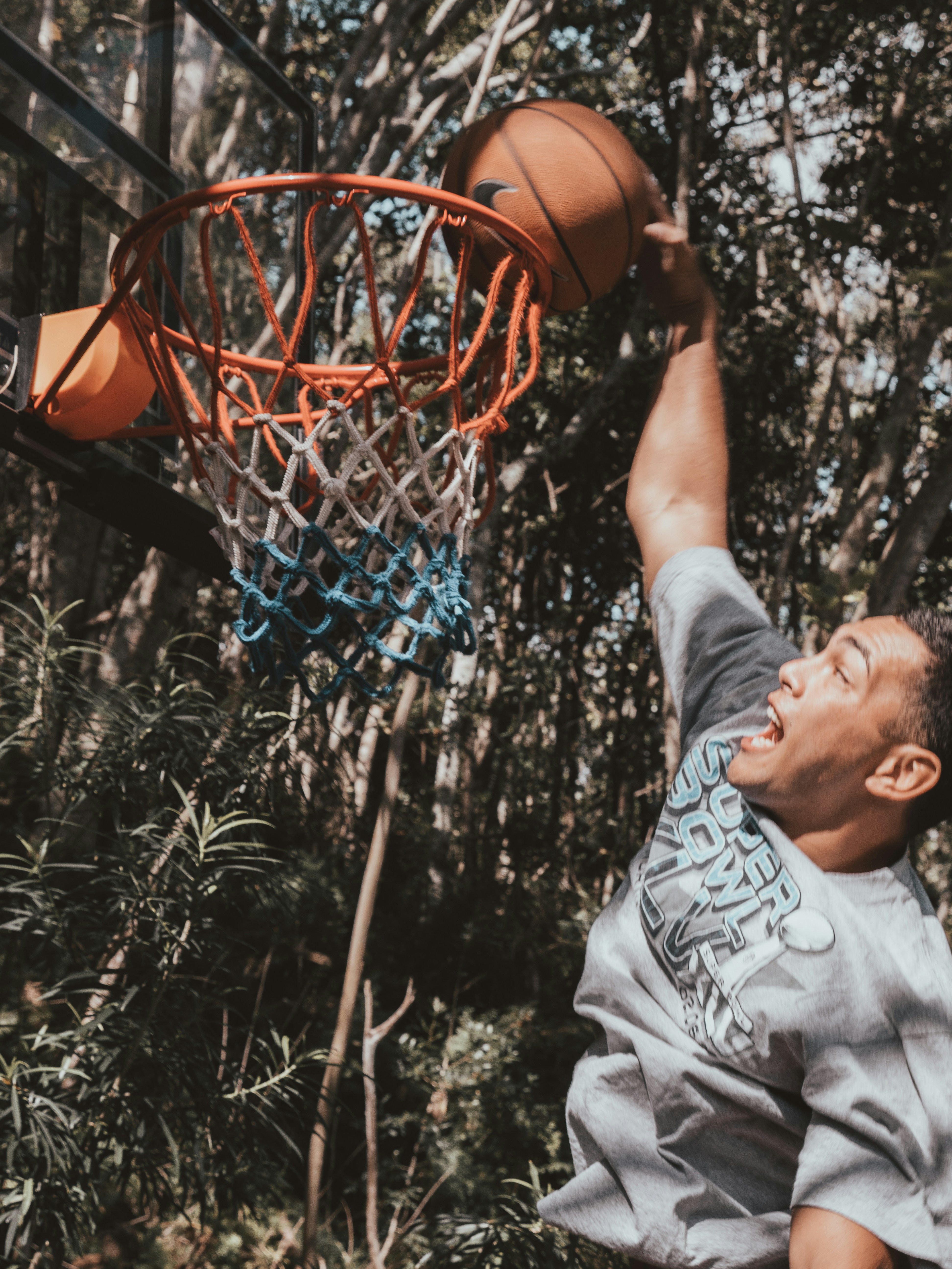 man in gray crew neck t-shirt holding basketball hoop