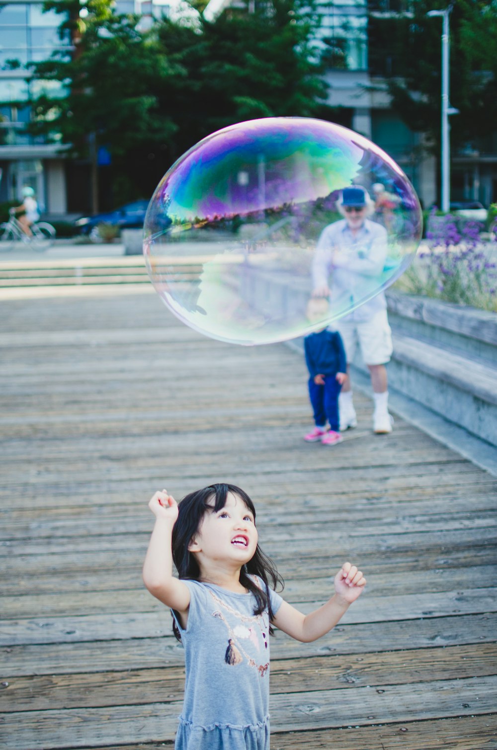 girl in pink shirt and blue denim jeans playing bubbles