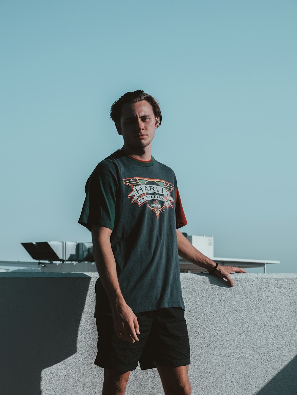 man in black crew neck t-shirt holding white tablet computer