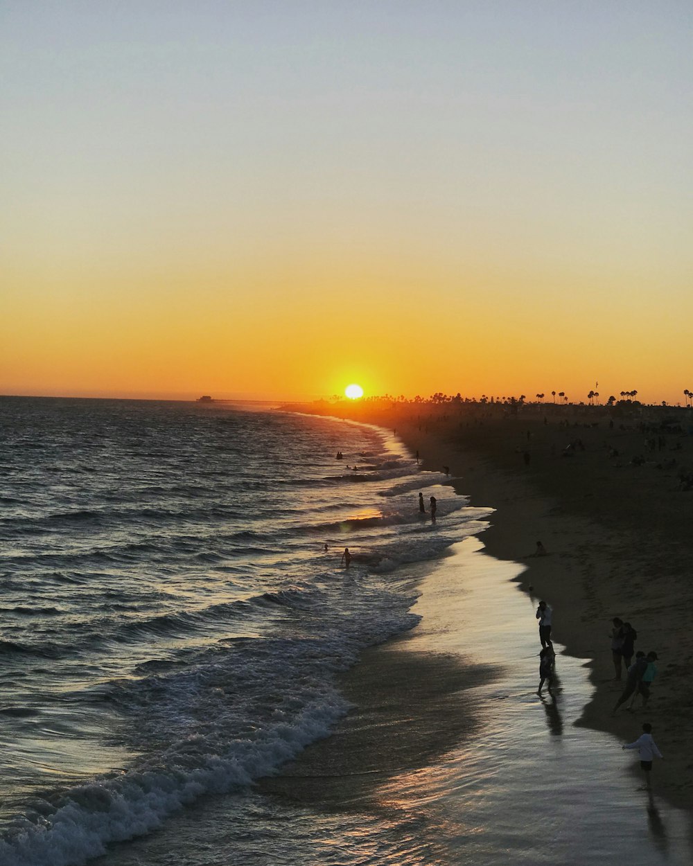 people walking on beach during sunset