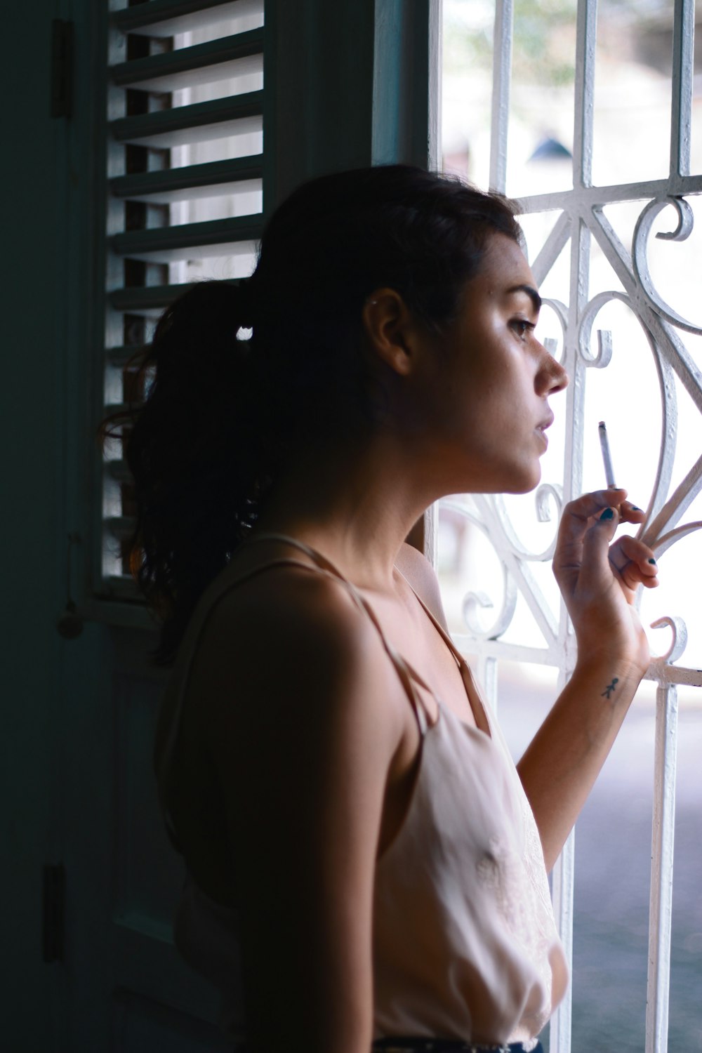 woman in white tank top holding smartphone