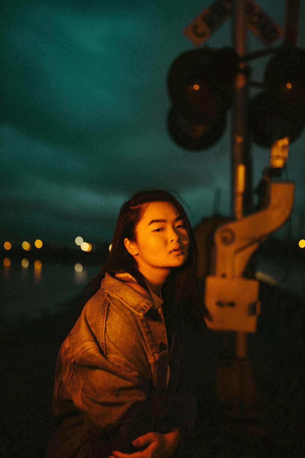 woman in brown jacket standing near lamp post during night time