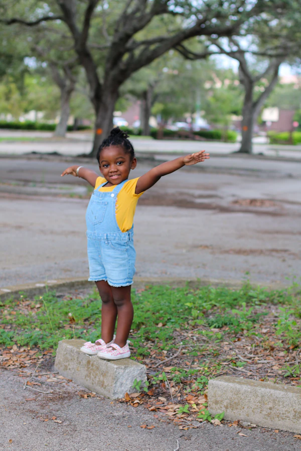 A young child standing outside, smiling