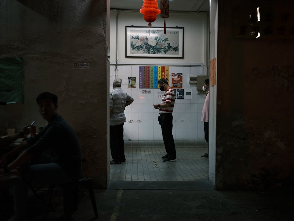 man in white shirt and black pants standing near door