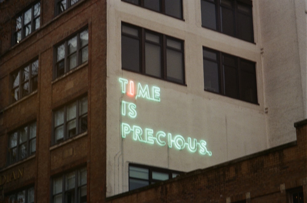 brown concrete building with green and white neon light signage