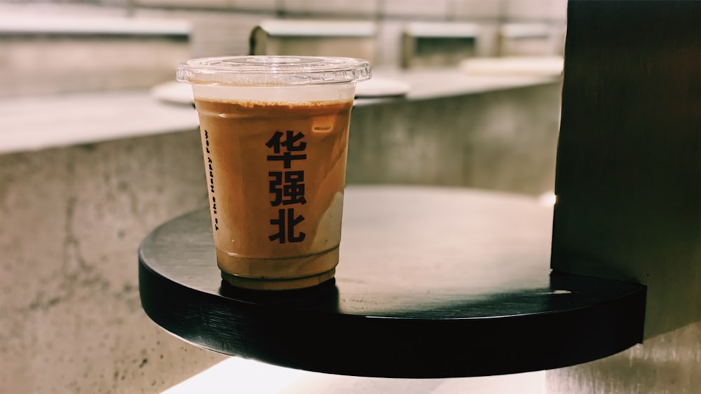 brown and white disposable cup on black round table