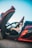 man in black jacket driving red convertible car