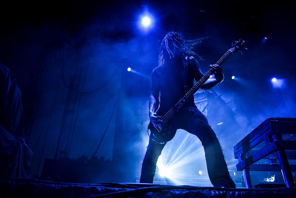 man playing guitar on stage