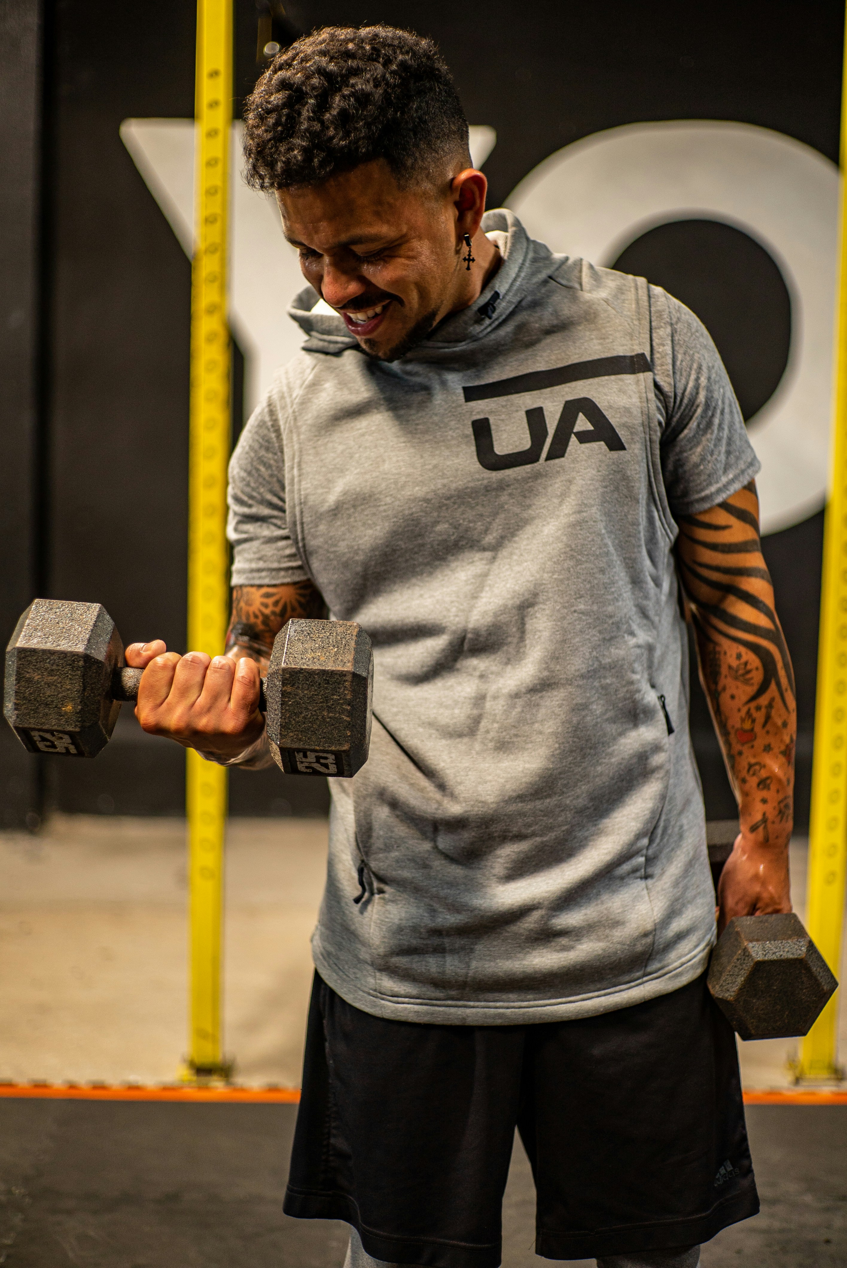 man in gray and black nike crew neck t-shirt holding black dumbbell