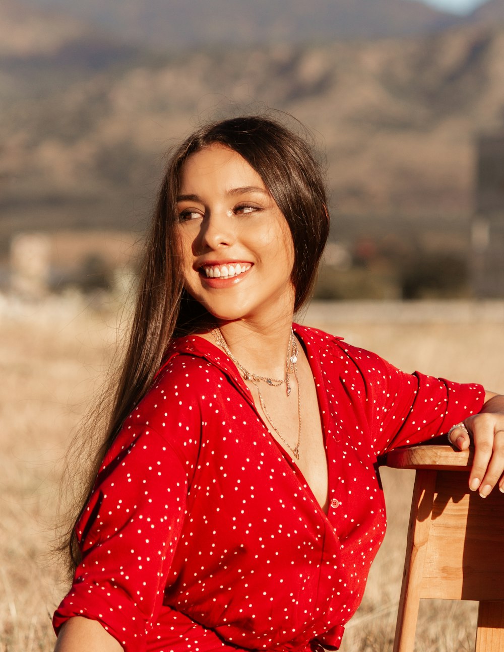 woman in red and white polka dot dress shirt smiling