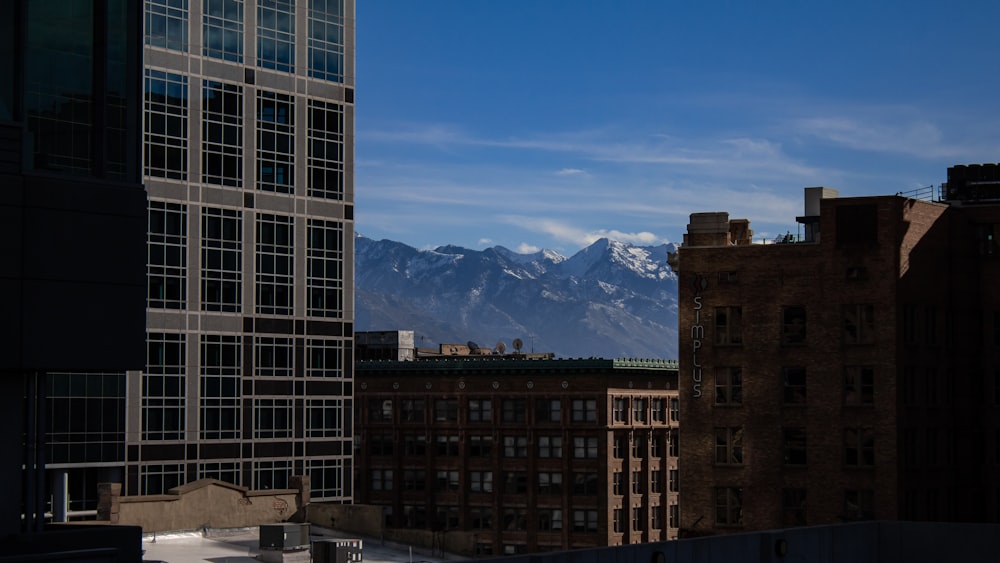 brown concrete building near mountain under blue sky during daytime