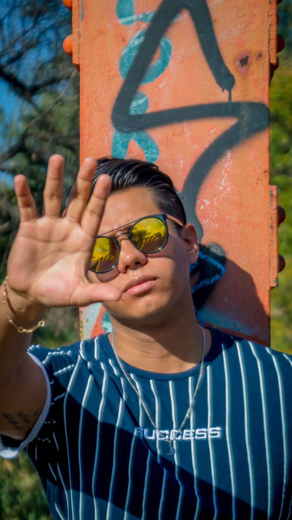 man in blue and white striped crew neck shirt wearing yellow sunglasses