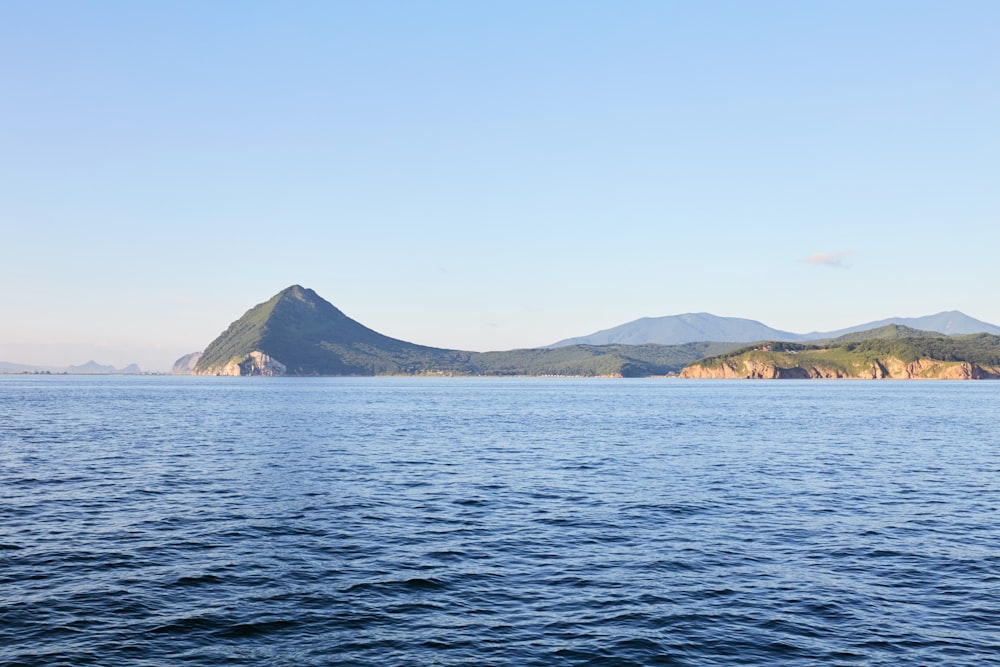 body of water near mountain during daytime