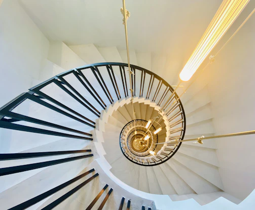 white spiral staircase with brown steel railings