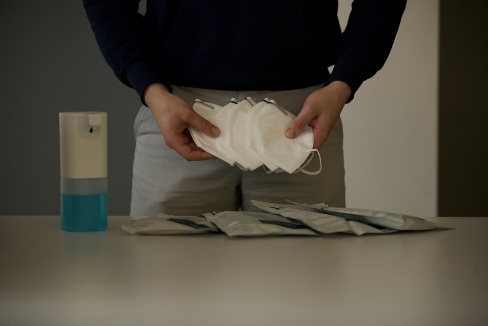 person in black long sleeve shirt holding white paper