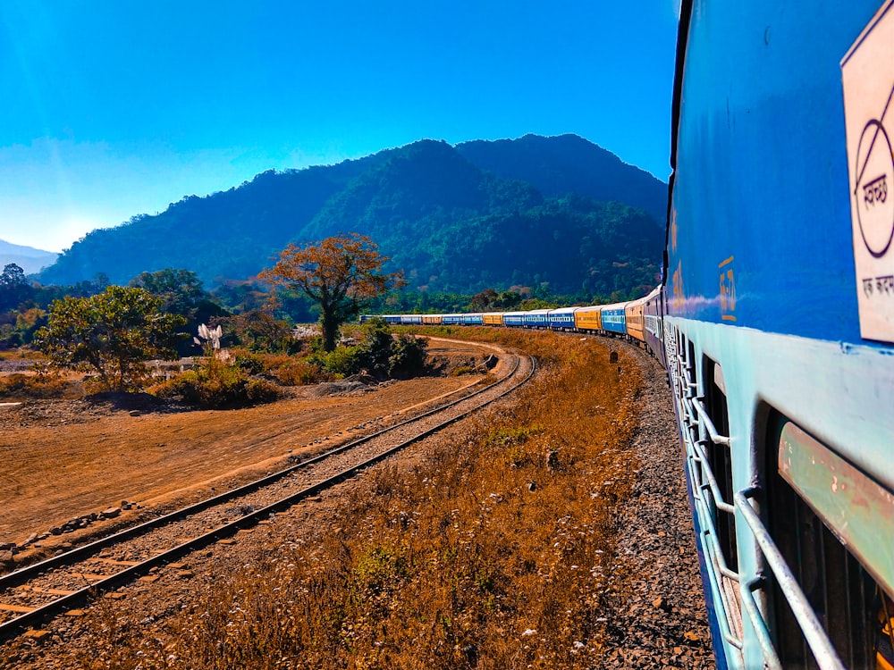 blue and white train on rail tracks during daytime