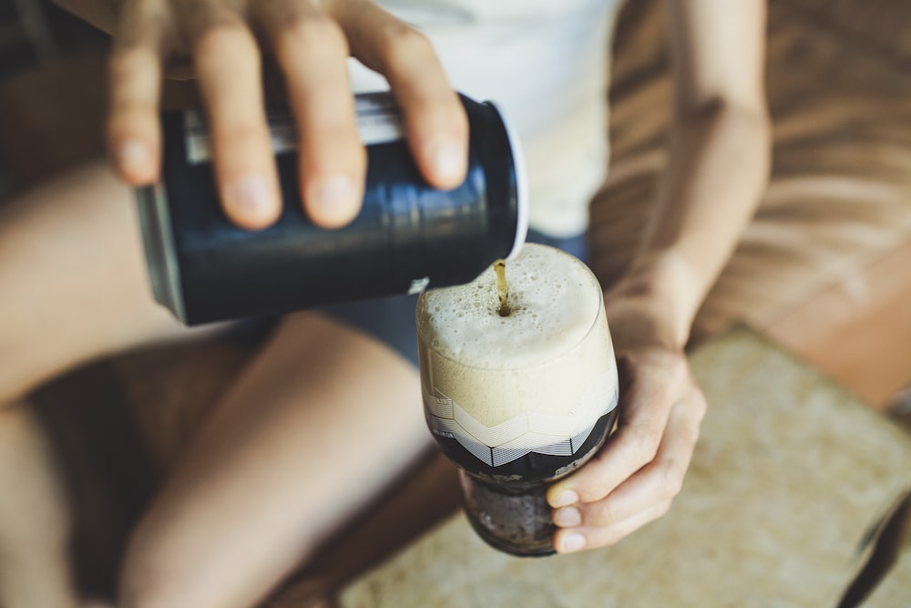 person holding black and white plastic bottle