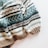 A cozy knitted sweater with a pattern of horizontal stripes in various colors. The texture is thick and the design includes alternating colors with geometric motifs.