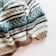 A cozy knitted sweater with a pattern of horizontal stripes in various colors. The texture is thick and the design includes alternating colors with geometric motifs.