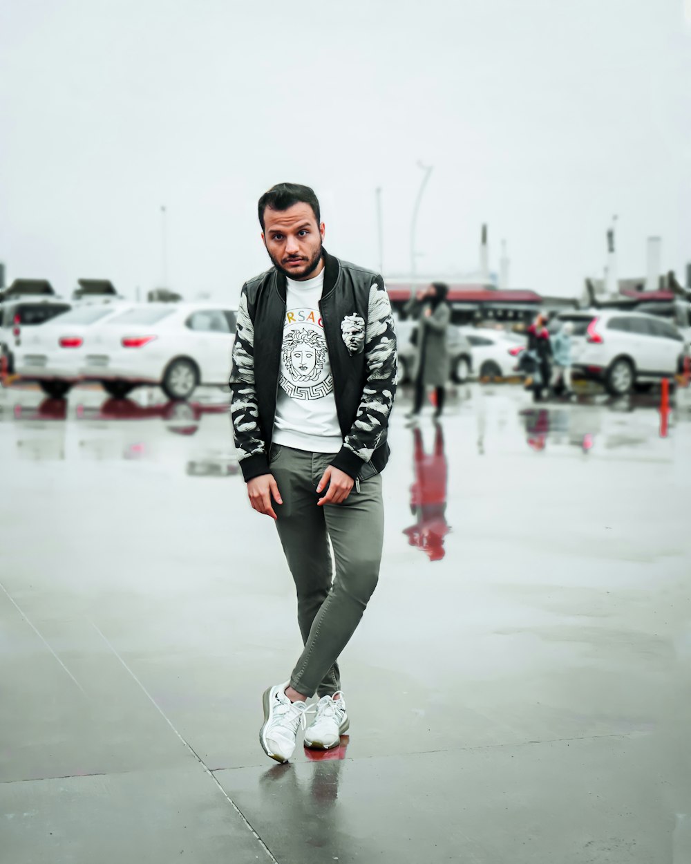 man in black and white jacket and black pants standing on white floor tiles during daytime