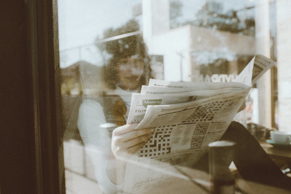 person reading newspaper inside room