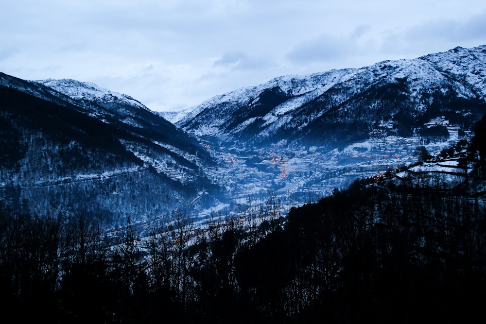 a snowy mountain range with a town in the distance