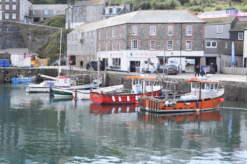 red and white boat on body of water near buildings during daytime