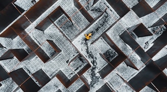 person in black pants walking on black and white concrete blocks