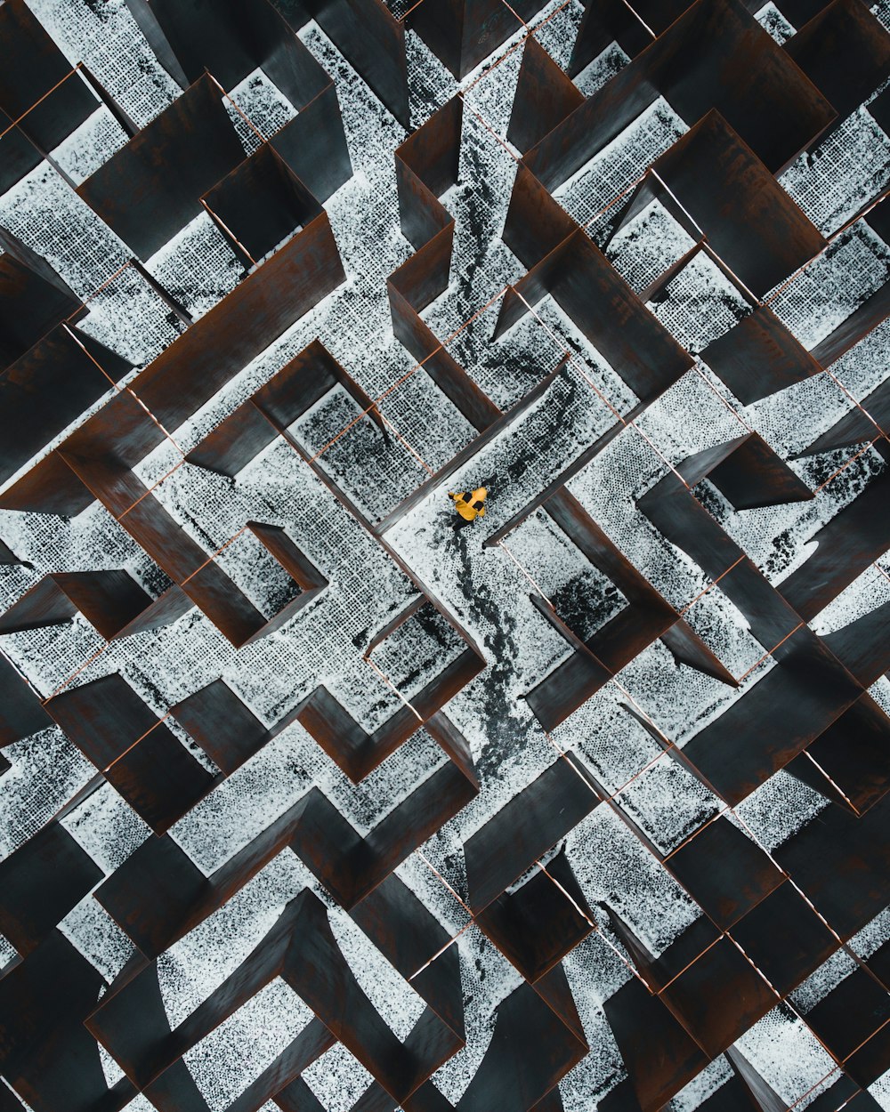 person in black pants walking on black and white concrete blocks