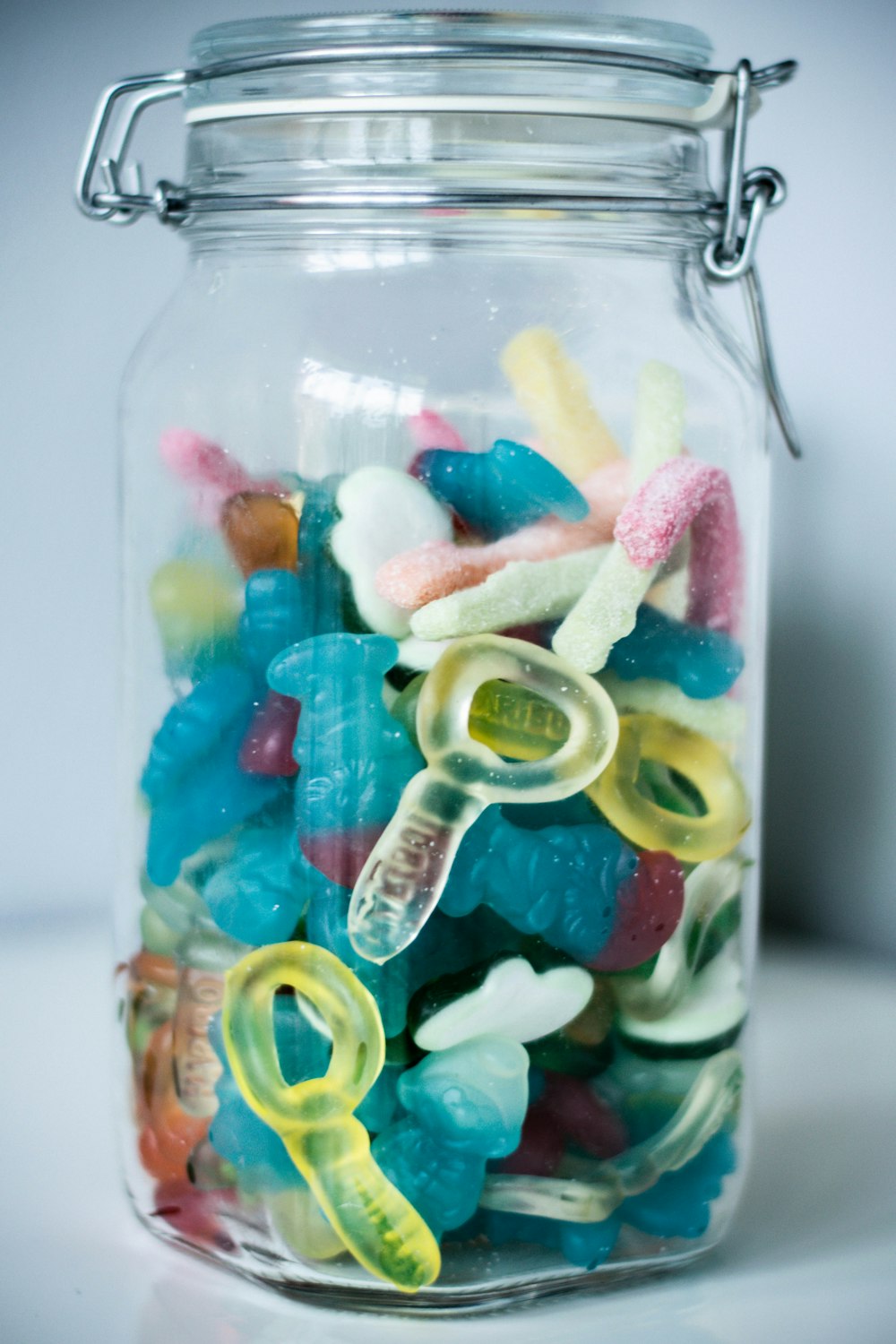 green blue and yellow candies in clear glass jar