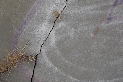 Close-up of a geopolimeric pot surface showing fine cracks being sealed by Bacillus subtilis bacteria.