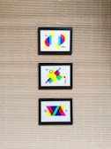 Colorful abstract artwork hanging on a clean white wall.