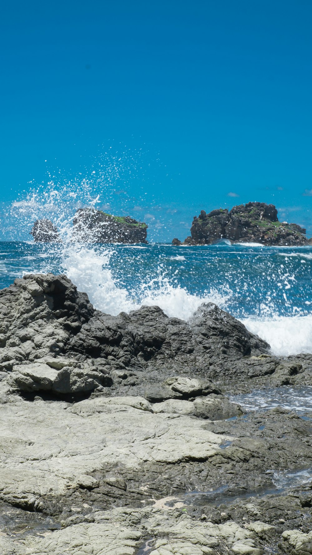 ocean waves crashing on rocky shore during daytime