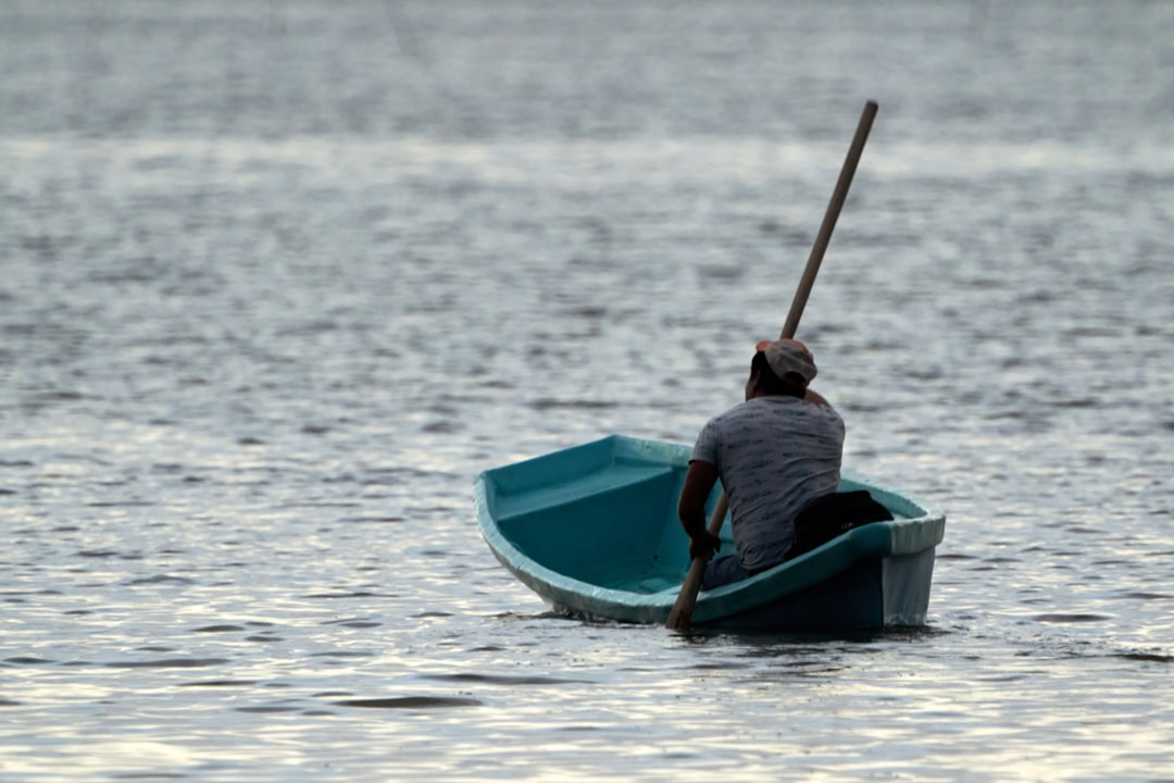 man in red shirt riding blue kayak on sea during daytime