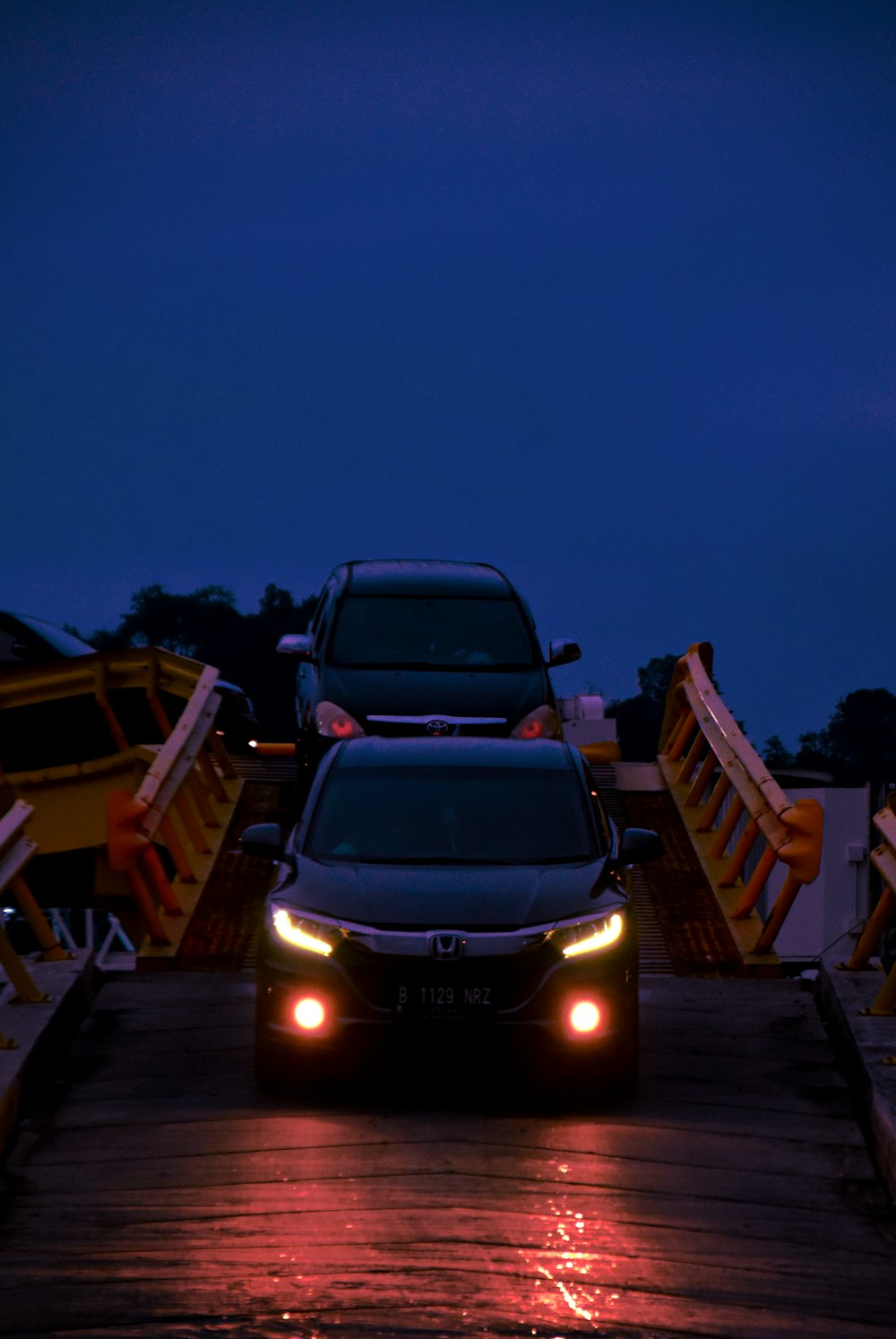 black car on brown wooden dock during night time