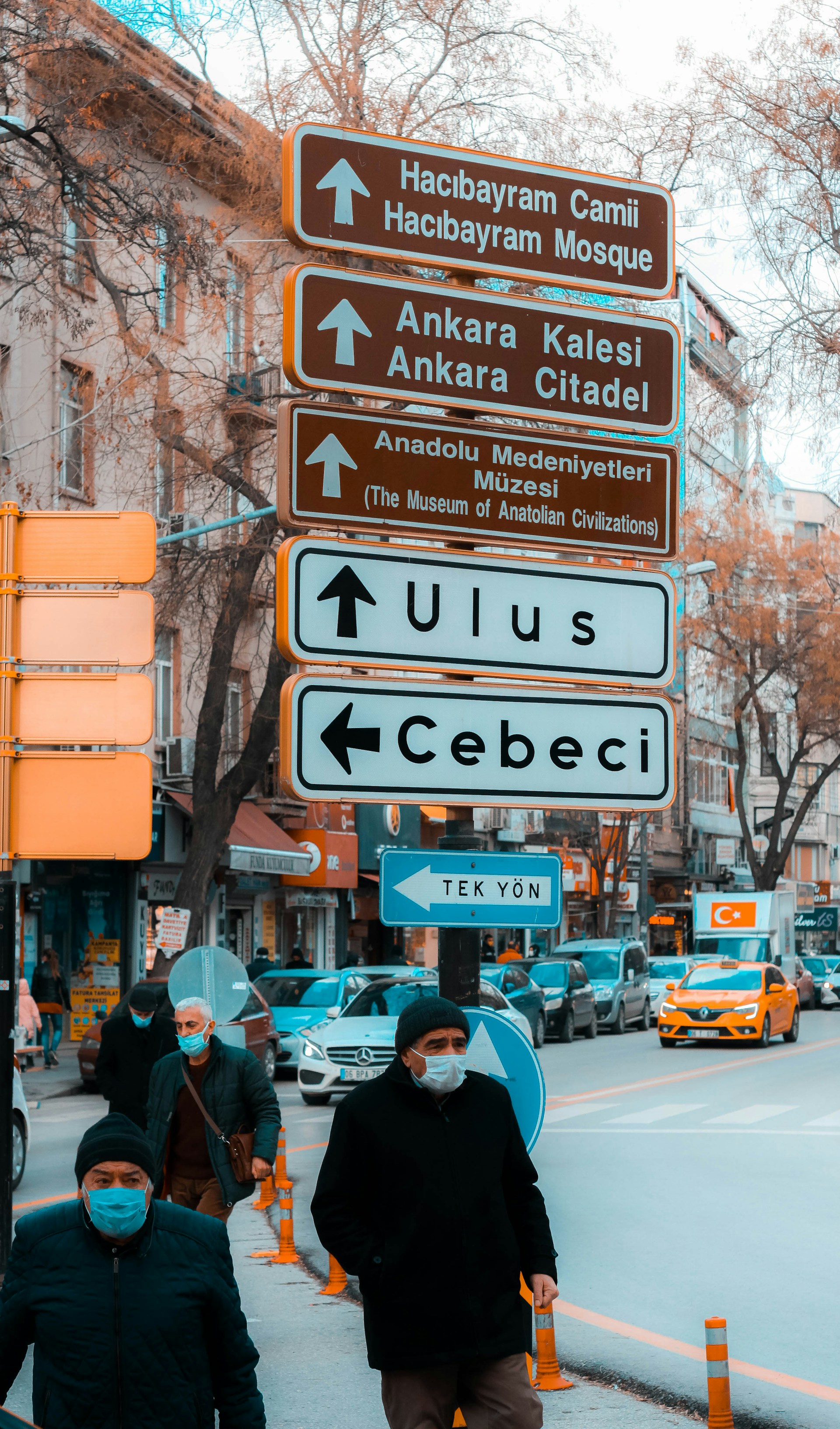 man in blue shirt standing beside road sign