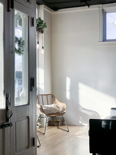 Sunlit living room of a Tiara Haven homestay unit with tropical plants and cozy seating.