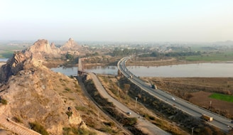 Image showing a completed road project winding through a scenic landscape under a clear sky.