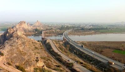 Image showing a completed road project winding through a scenic landscape under a clear sky.