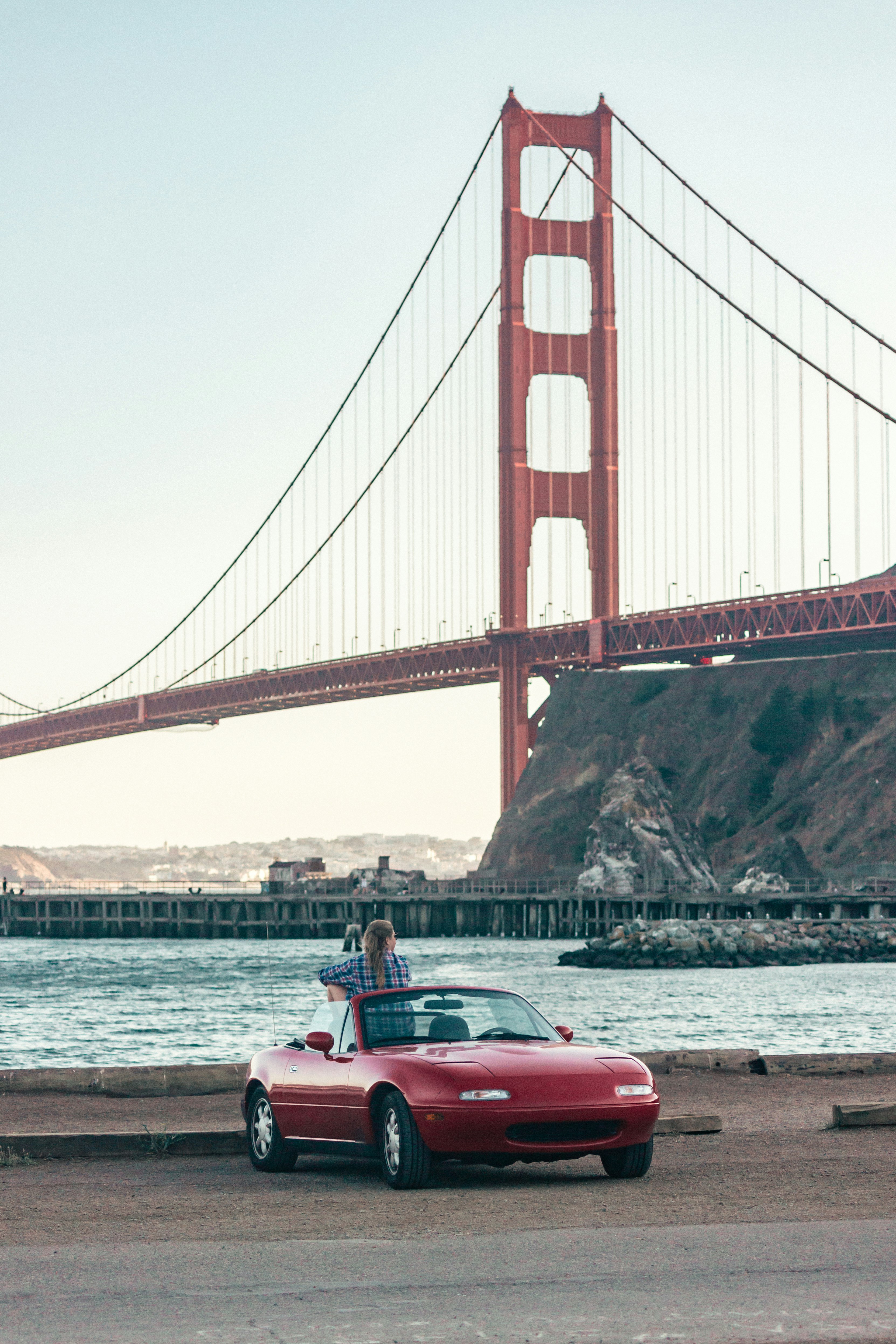 red and white convertible car on bridge during daytime