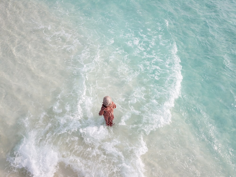 woman in black and white polka dot dress on body of water during daytime