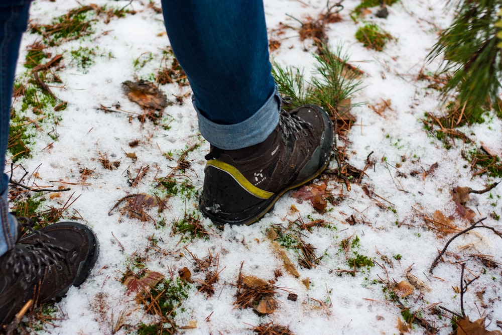 person in blue denim jeans and black hiking shoes