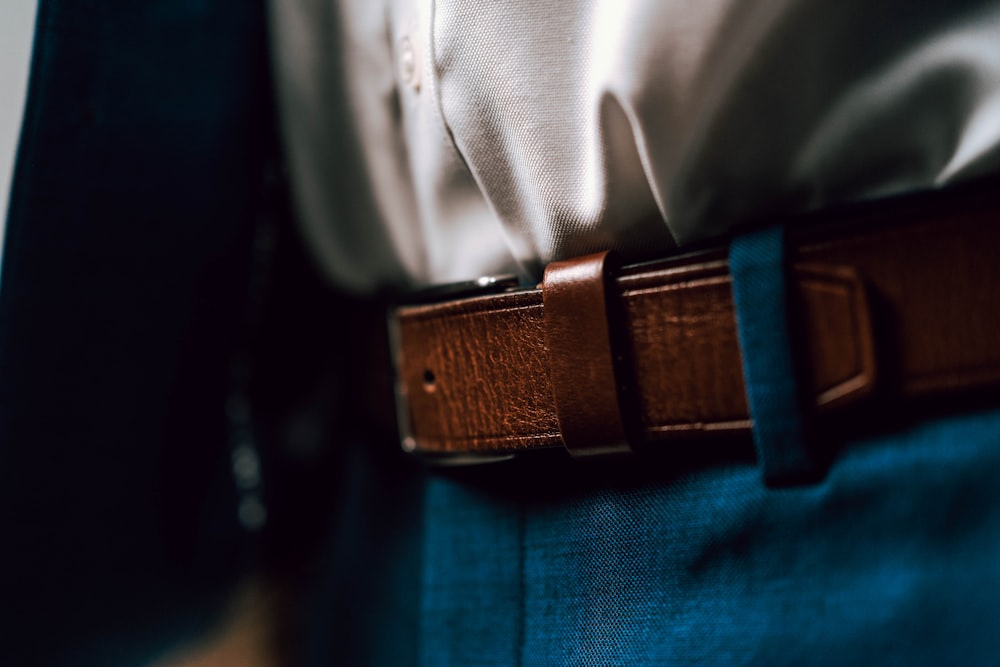 Cinturón de cuero negro sobre jeans de mezclilla azules