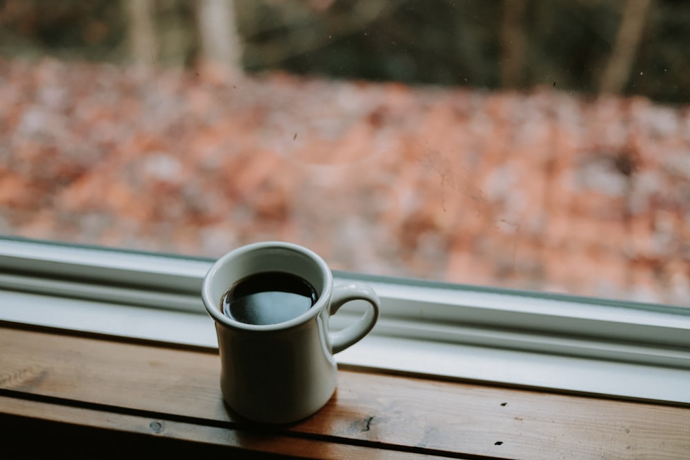 white ceramic mug on brown wooden table